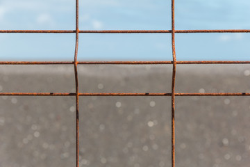 Iron fence with corrosion before horizon.