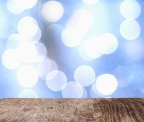 Fototapeta na wymiar Rrustic wood table in front of glitter and bright bokeh lights