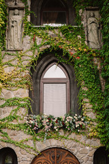 Fototapeta na wymiar Old stone wall with a wedding decorated window