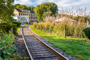 Fototapeta na wymiar Railway Track Running Through a Village on a Sunny Autumn Day
