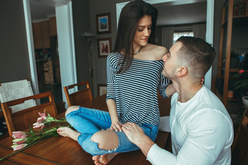 Portrait of beautiful romantic young couple man woman in love looking at each other indoors at home, toned with filters,  lifestyle candid