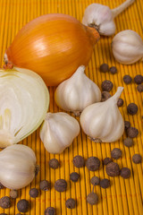 Onions, garlic and pepper on a background of wood
