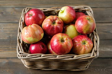 Fototapeta na wymiar basket with red ripe apples on a brown wooden table