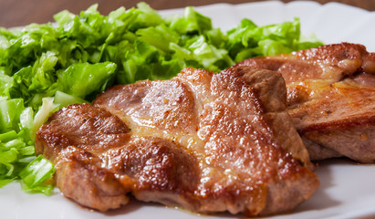 meat fillet steak with vegetables salad in a plate on wooden table
