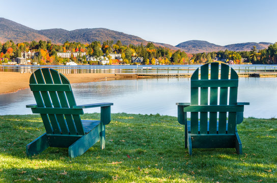 Couple of Green Adirondack Chairs on the Shore of a Lake on a Fall Morning