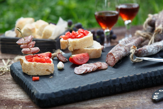 Cured dry sausage with wine, bread and tomato