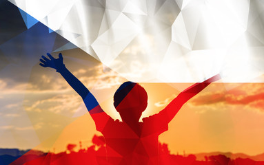 Young man raising his hands on a sunset background with a flag background - 139373536