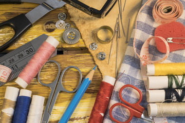 Sewing tools and acessories on brown wooden background