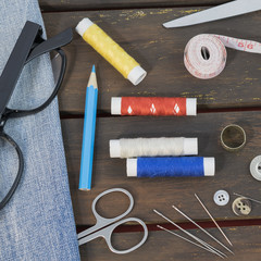 Sewing tools and acessories on brown wooden background