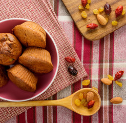 Freshly baked homemade muffins with cranberry raisins and nuts on napkin.
