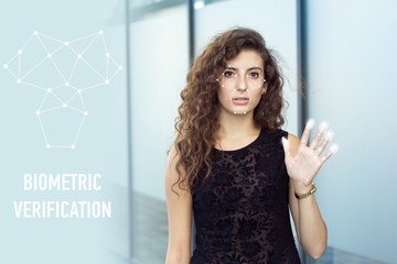 Frightened curly girl holds open hand, biometric verification. Scanning of personal data.