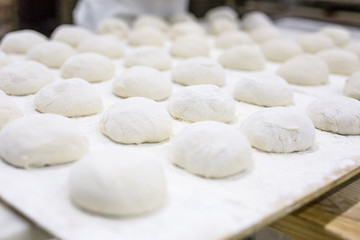 Fototapeta na wymiar Hands hold the dough and the bread