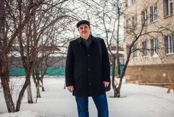 Portrait of a handsome man in a coat on the street