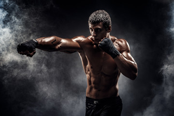 Muscular topless fighter in boxing gloves