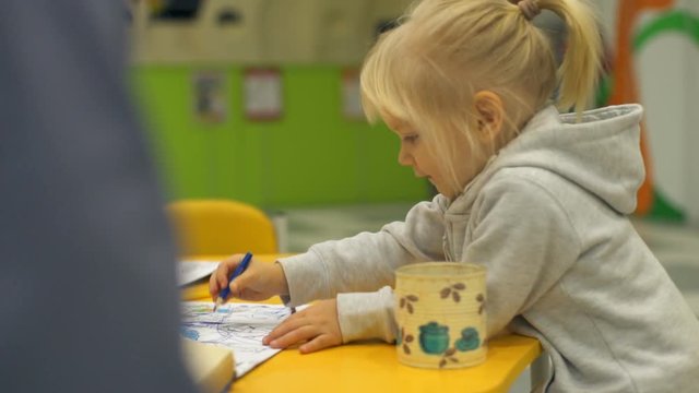 Cute little girl drawing a colorful picture and smiling slow motion