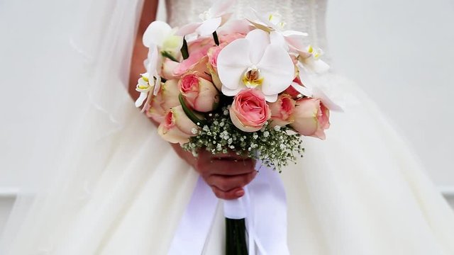 bride with flowers in hand with orchids and roses