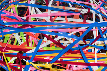 Abstract of jumbled colorful plastic ribbons stretched and crisscrossed up, down, and sideways.