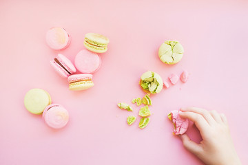 Group of macarons and child's hand holding macaron.