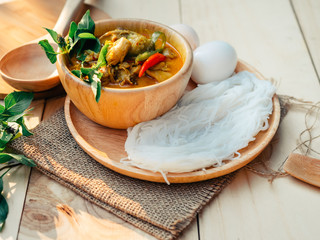 Vintage Thai traditional food style Thai vermicelli eaten with green curry chicken hot and spicy(Kanom jean keawwhan kai) on wooden background wallpaper focus one point shallow with depth of field