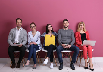 Group of people waiting for job interview on colour background