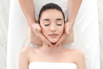 Obraz na płótnie Canvas Beautiful young woman receiving facial massage in spa salon