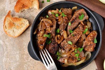 Fried liver with onions and apples on a concrete background - 139379332