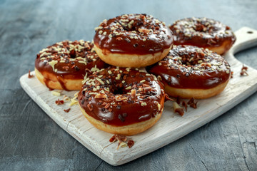 donut rings with white and dark chocolate chippings and icing served on board