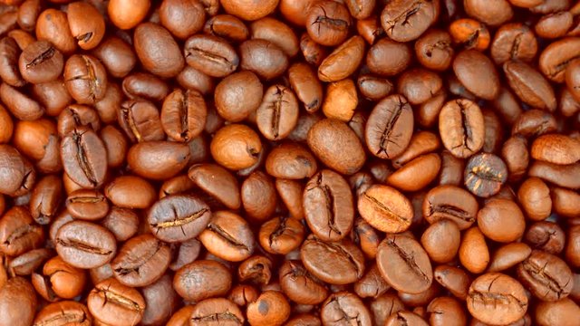 Coffee beans rotating background. Roasted coffee closeup