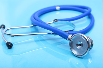 Stethoscope and medical equipmenton on blue background