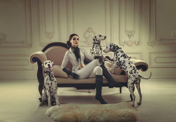  Stylish girl in a suit rider poses with Dalmatian. Creative colors