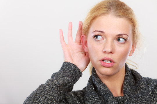Woman put hand to ear for better hearing