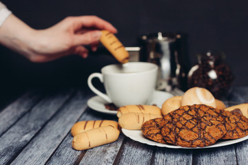 cup with a drink and a cookie in his hand