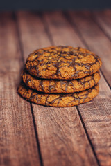 three cookies with chocolate icing on a wooden table