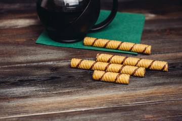sweet tubes and a teapot on a napkin