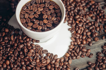 Coffee beans in a cup and on a table