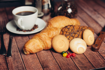 Biscuits, sweets, coffee mug tea on the table, croissant
