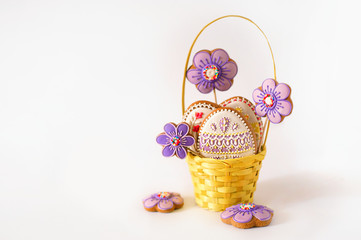 Little Easter is on a festive scarf. Multi-colored Easter eggs lie in a basket with decoration gingerbread