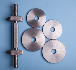 steel dumbbell isolated on bright blue background