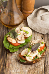 vegetable sandwiches, a bottle with oil and spices on a wooden table top view.