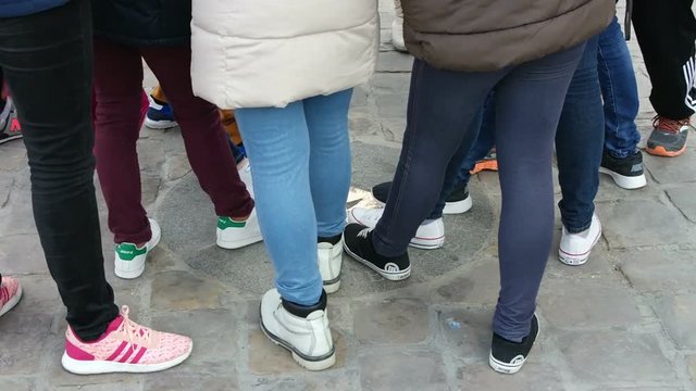 Children legs near Notre Dame de Paris Cathedral, France. Zero point in front of Notre Dame Cathedral. Tradition tourists stepped on foot
