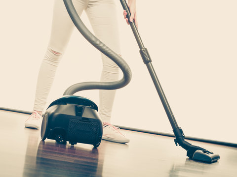 Woman legs and vacuum cleaner