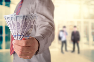 Businessman with money in hand, US dollar (USD) bills - investment, success and profitable business concepts