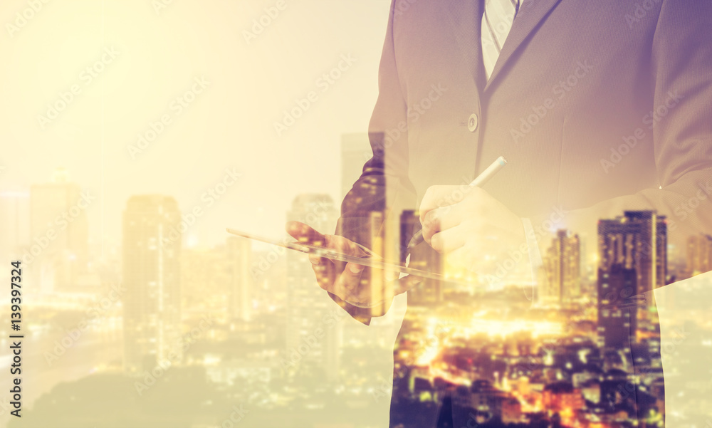 Poster double exposure of business man working with a digital tablet with cityscape blurred building backgr