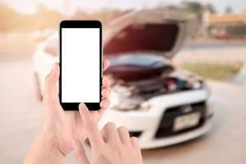 closeup of hand with smartphone a white screen on broken car background.transportation,  vehicle concept