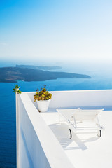 Fototapeta na wymiar Chaise lounge on the terrace with sea view. Santorini island, Greece