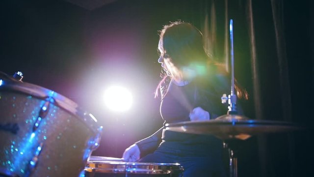 Passionate girl playing the drums - rock performing, slow motion