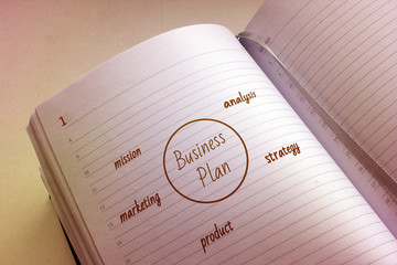 Open paper notebook and pictured business plan scheme with vintage style effect