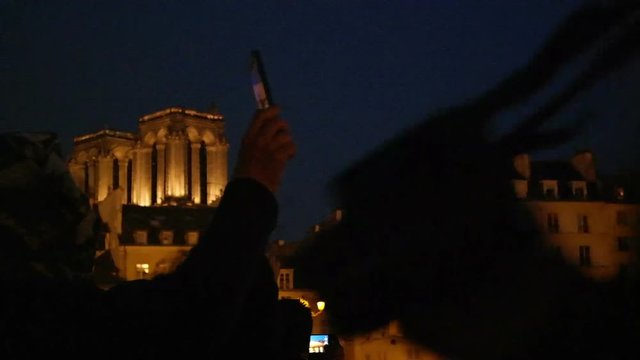 Seine River cruise on boat tour. Vehicle shot in Paris, France. View of Notre Dame de Paris. Tourists take pictures in the dark cathedral