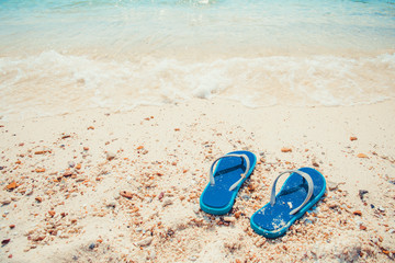 Summer vacation concept - slippers on tropical beach. Leisure in summer - vintage color tone effect