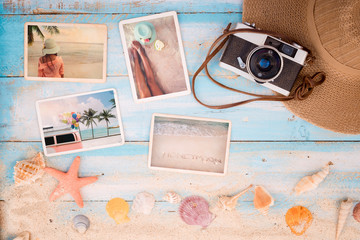 Top view composition - Summer photo album with starfish, shells, coral and items on wooden table....